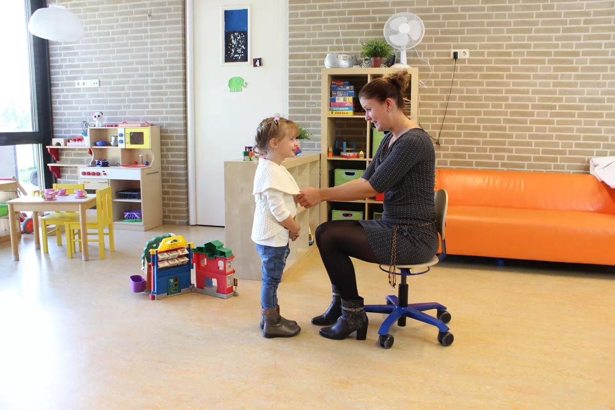 2a1377d4009476a99d93fc23a426aed99b5ed8d5_Pico_environnement_72dpi_1200x800.jpg Adulte assis sur un siège Pico bleu interagissant avec un enfant dans une école